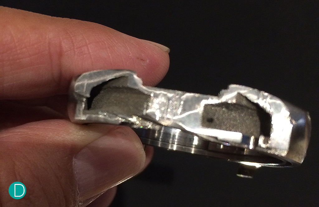 A cut away of the direct metal laser sintered case of the PAM578 showing the hollow insides. Note the rough texture of the insides, but the smooth, monolithic structure of the case walls that has been sliced through. The outer surface of the case is also a similar rough texture, which is then polished to the required specifications.